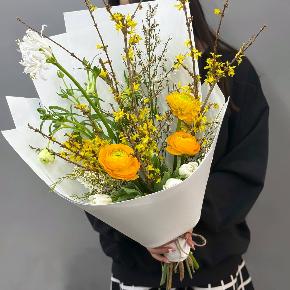 Весенний букет с желтыми ранункулюсами и цветущими ветками форзиции в Чехове